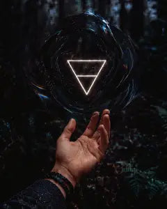 A hand beneath a glowing earth-symbol orb in a dark forest